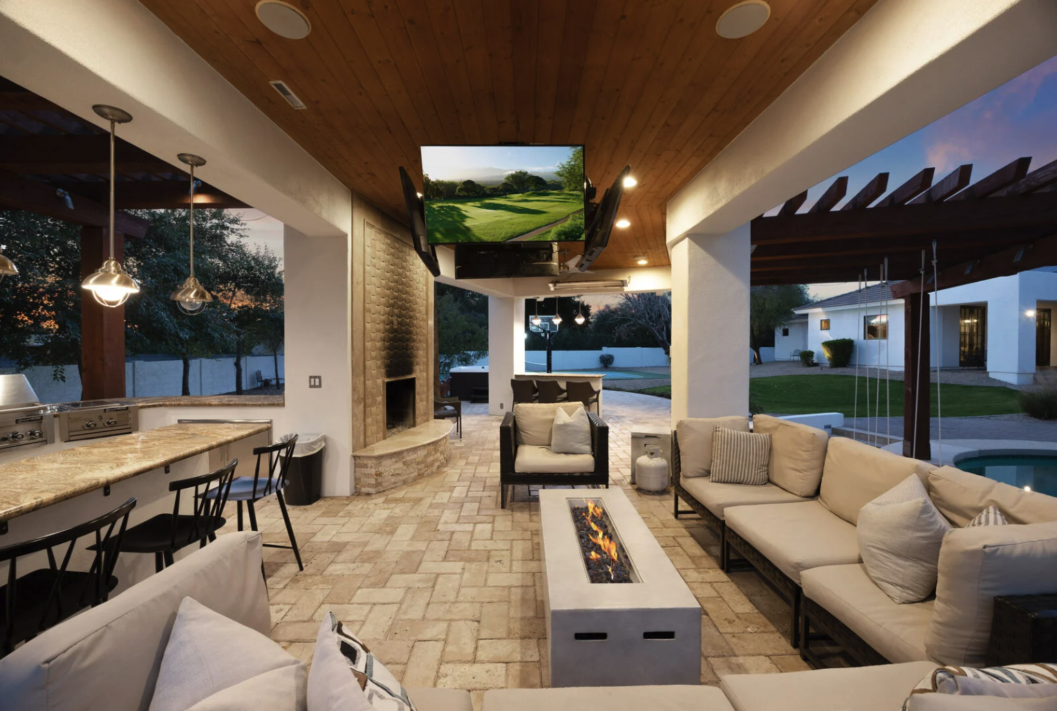 Luxury outdoor living space with modern furniture, fireplace and pool area